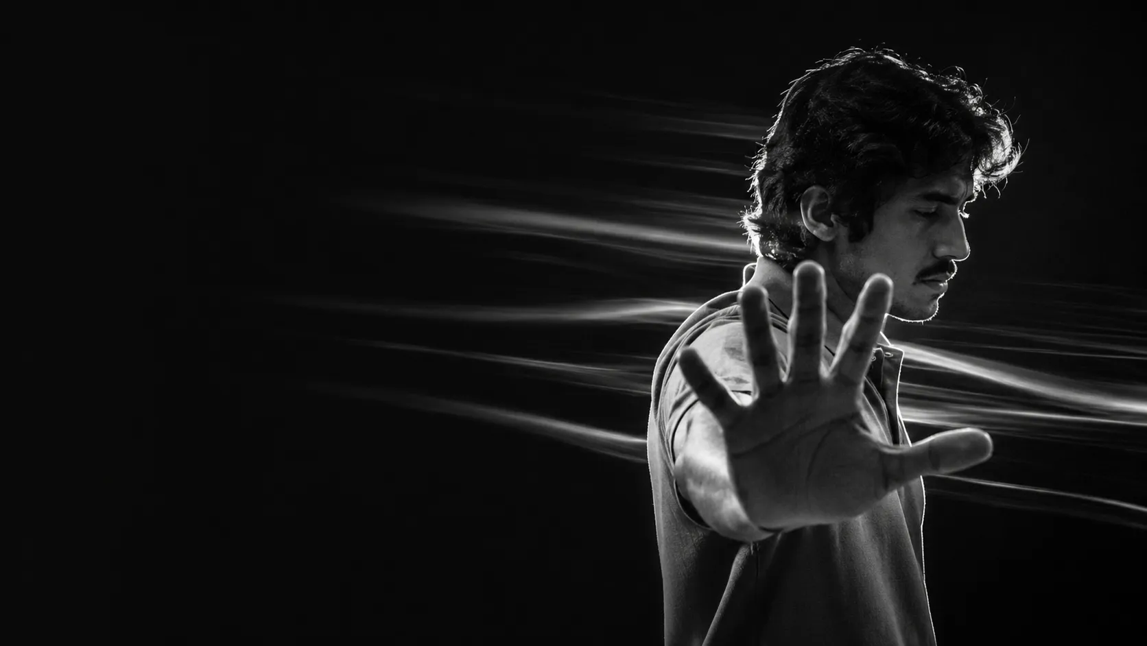 Umer Mehmood reaching toward the camera, light trailing from his hand